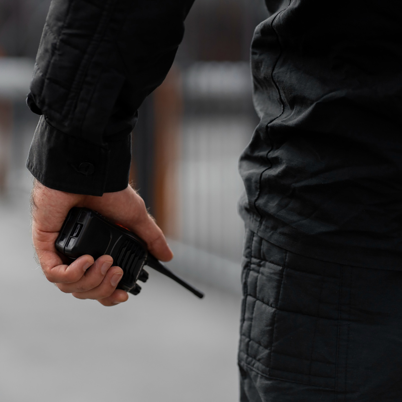 Professional Guardion Protection uniformed security officer equipped with a two-way radio providing onsite surveillance and rapid response services.