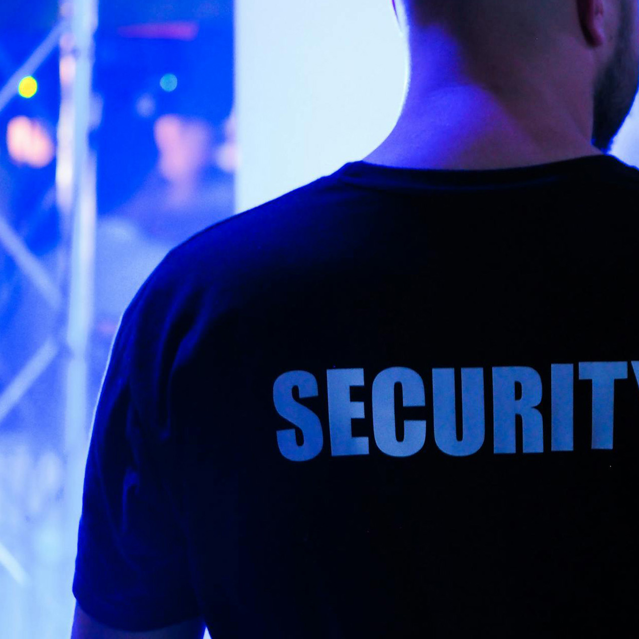 Close-up of a Guardion Protection event security specialist in a black uniform monitoring a venue to ensure guest safety and crowd control.